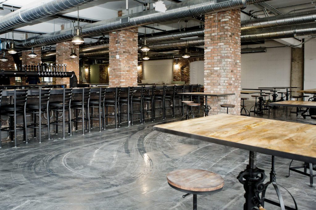 photo of an empty brewery with square posts covered in thin brick veneer.