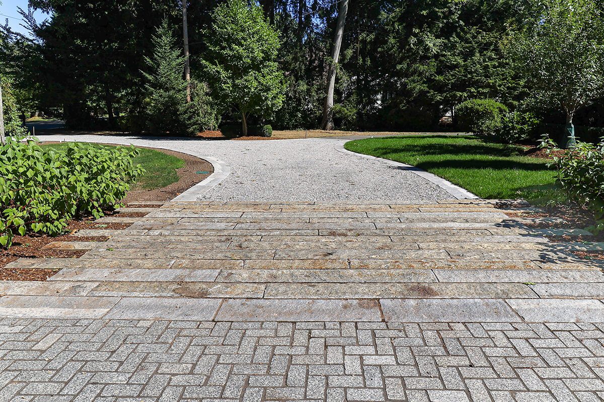 Curbing apron between chelsea cobbles and gravel driveway