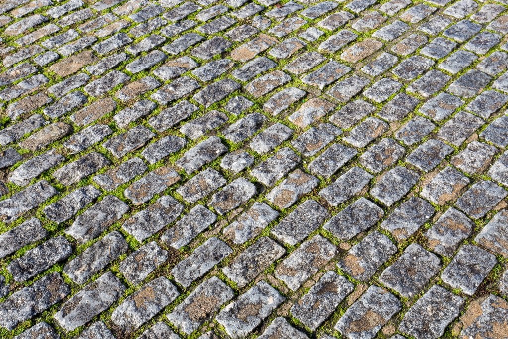 A close-up picture of a road paved with granite Belgian blocks, also known as setts.