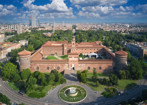 phot of Castello Sforzesco, in Milan, Italy.  Downtown Milan is in the background, with the large, square brick castle in the foreground.