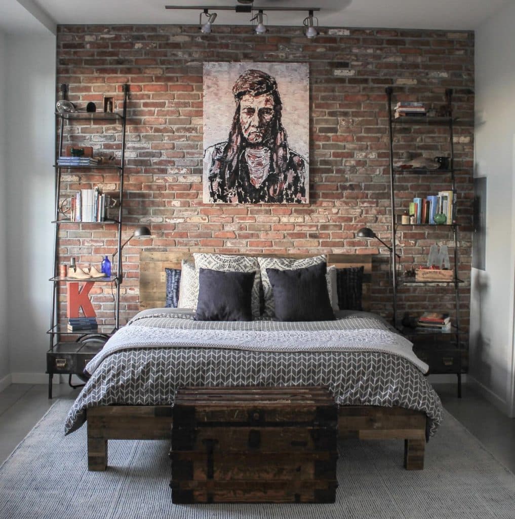 photo of a bedroom with a bed placed in front of a wall made from reclaimed thin brick veneer.