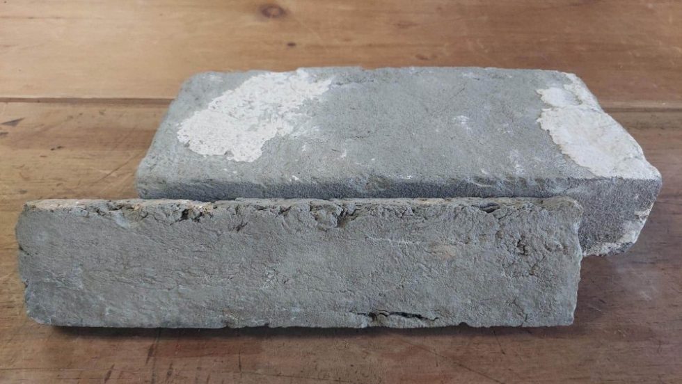 A sample of antique grey reclaimed face brick, with a thin veneer piece in front of it.