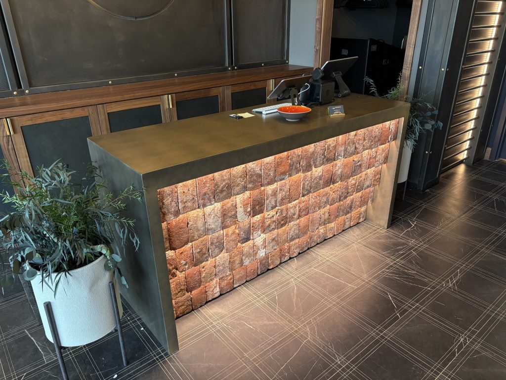 Thin brick floor tile used for a restaurant hostess stand, with featured lighting.