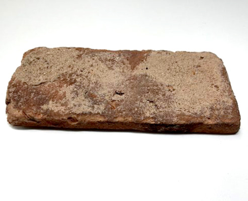 Reclaimed brick floor tile in close-up view.