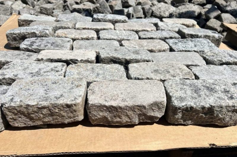 Sliced granite cobbles displayed side by side on a pallet.