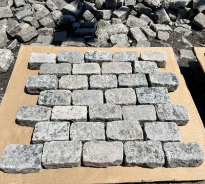 The top halves of granite cobbles that have been split in two, laid out on a piece of cardboard.