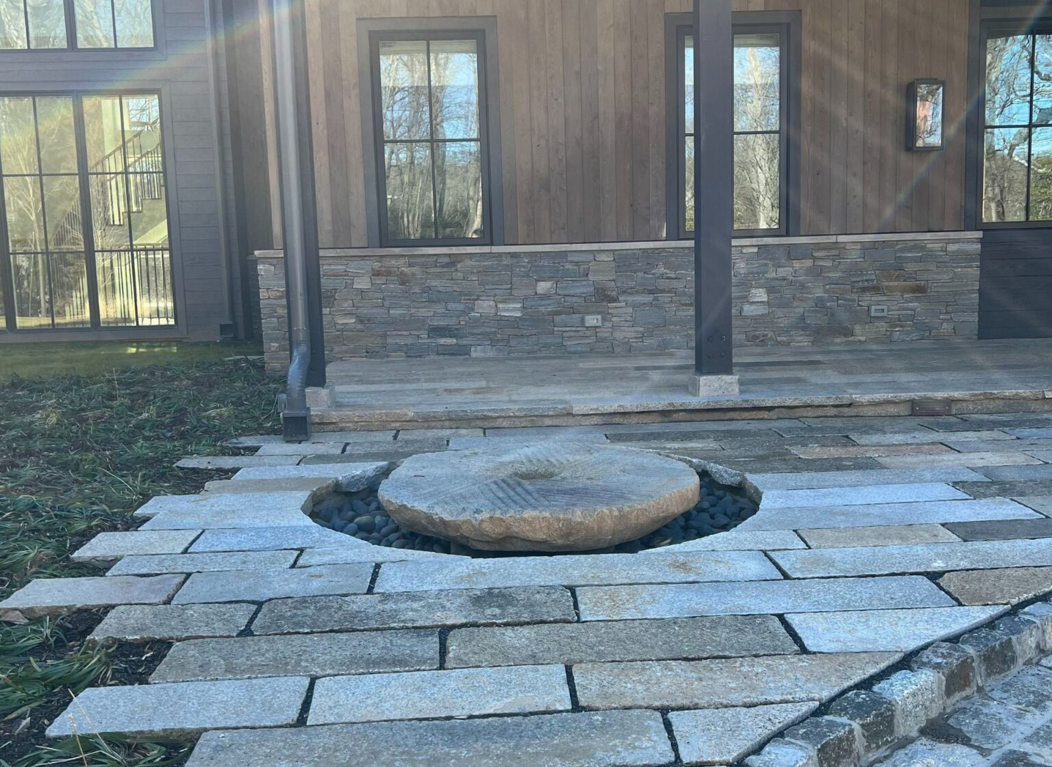 a reclaimed millstone set within a granite stone patio.
