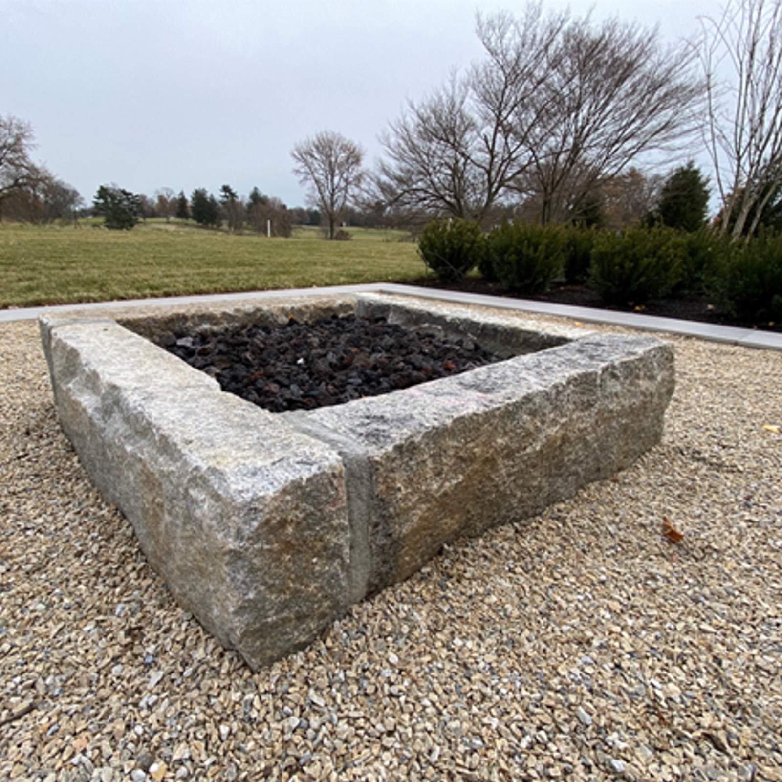 a square firepit made from curb-grade reclaimed granite curbing