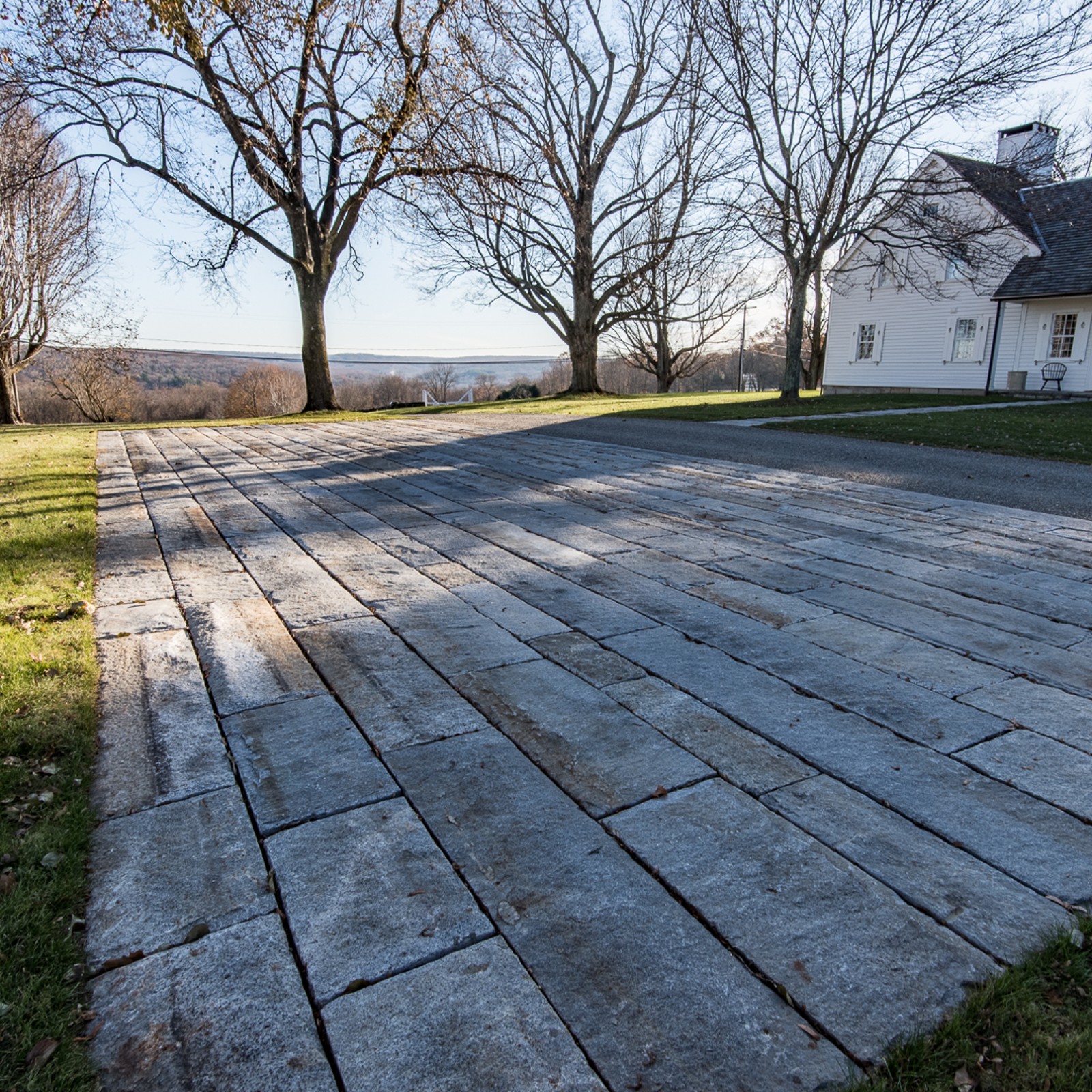 Reclaimed granite curbing used for a wide parking area, with a scenic view of a valley in the distance