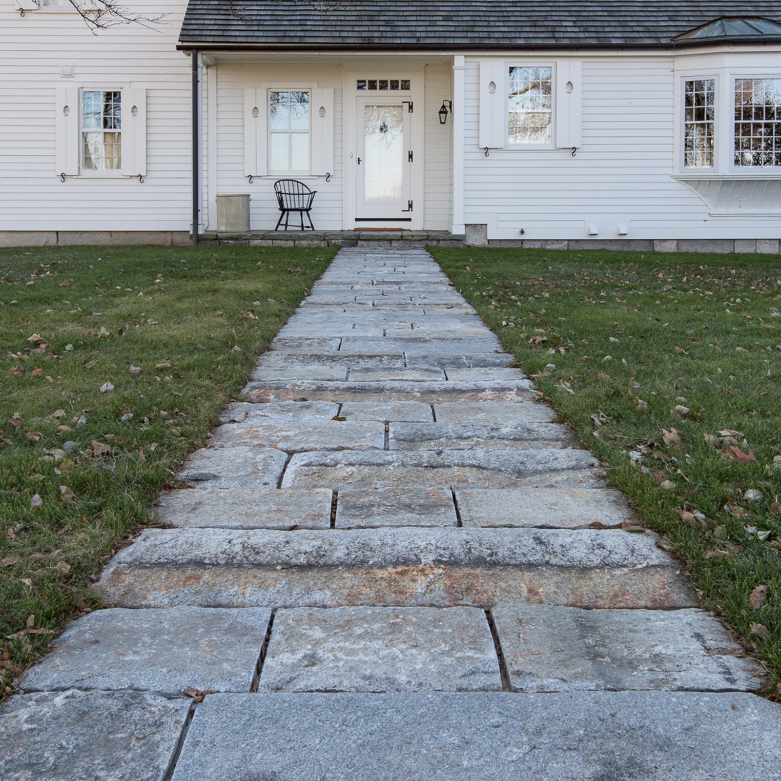reclaimed granite curbing used for a long walkway leading to the front door of a home.