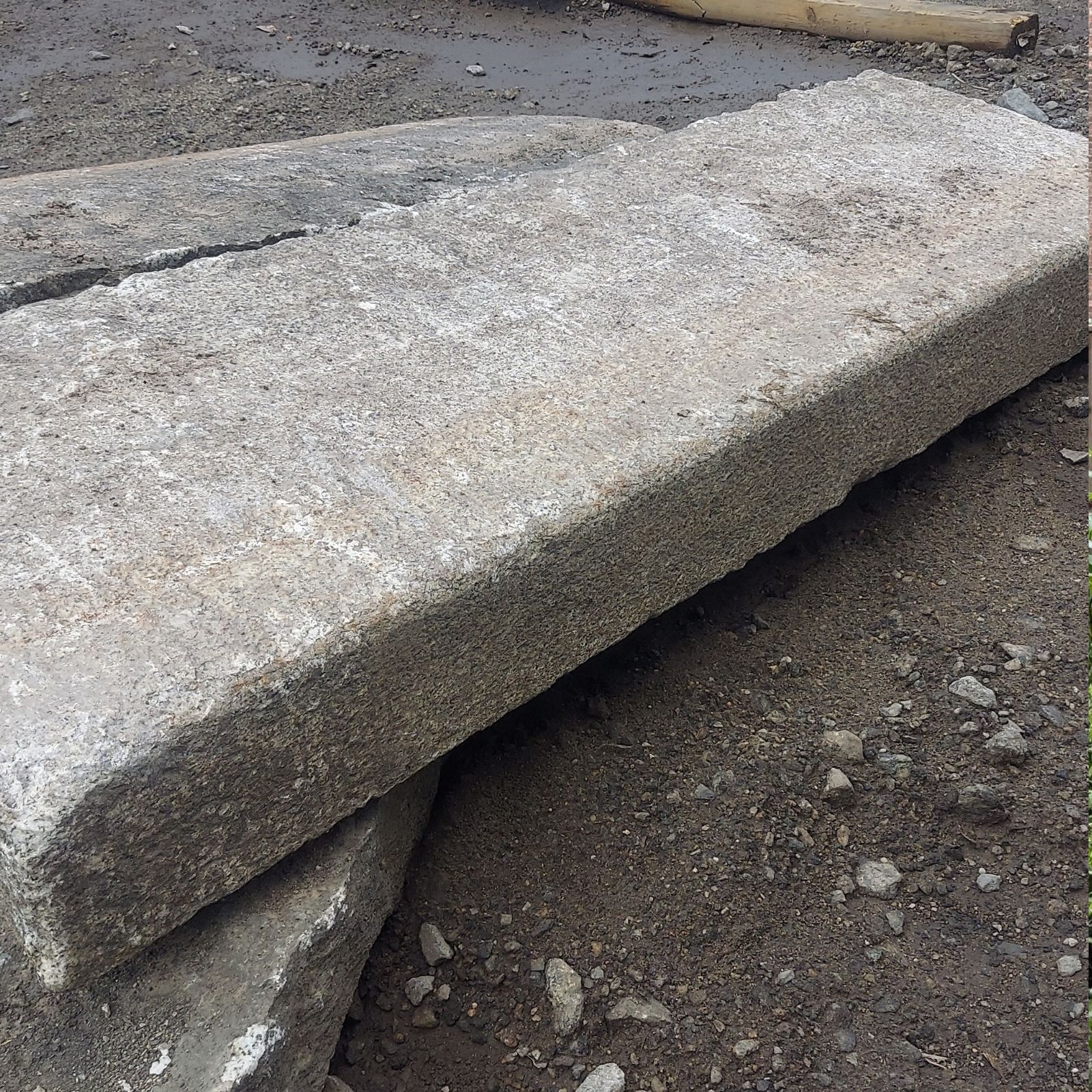 A closeup image of granite curbing with a smooth, flat side and natural edge.