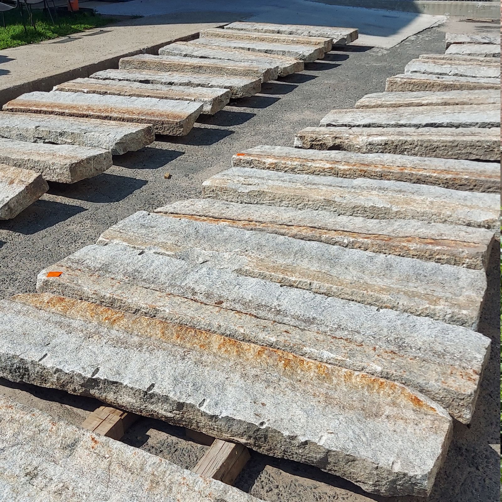 several pieces of reclaimed granite curbing laid out in two long rows.